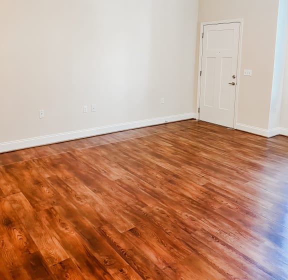 an empty living room with wood floors and a ceiling fan
