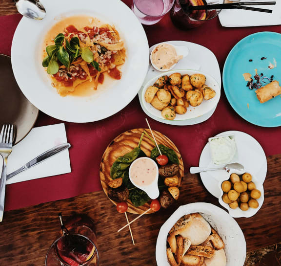 a table filled with plates of food and glasses of wine