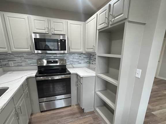 A kitchen with a refrigerator, oven, and sink at Briarcliff at Quechee Apartments, Vermont