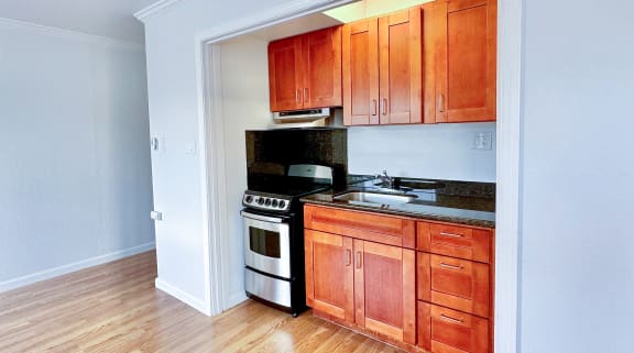 a kitchen with wood flooring and a stove and cabinets at The Chase Apartment Homes, Oakland California