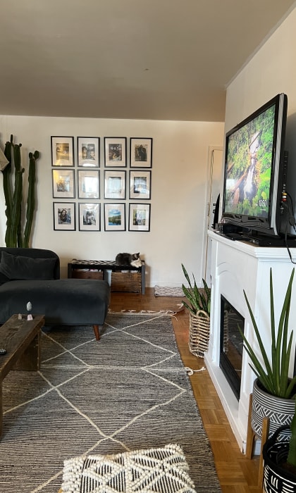 a living room with a tv on the wall and a desk with a chair