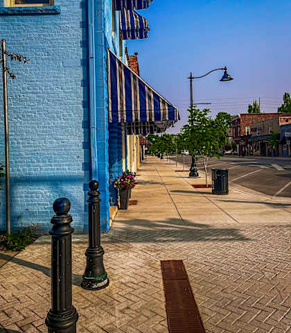 a blue building with a striped awning on a city street at Ridgeview, Fortville, Indiana