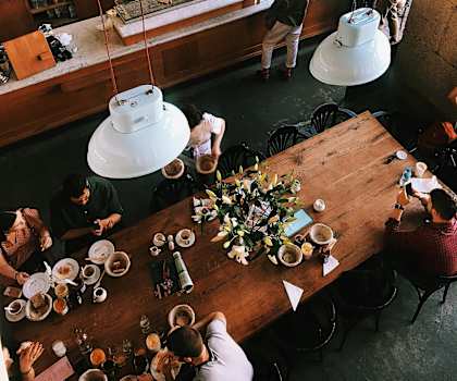 A group of people are sitting at a long table in a restaurant.