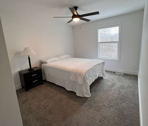 a bedroom with a bed and a ceiling fan