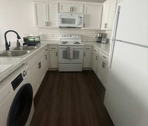 a kitchen with a stove top oven next to a microwave