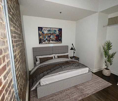 a bedroom with a bed and a brick wall at Union Alley, Memphis, TN, 38103