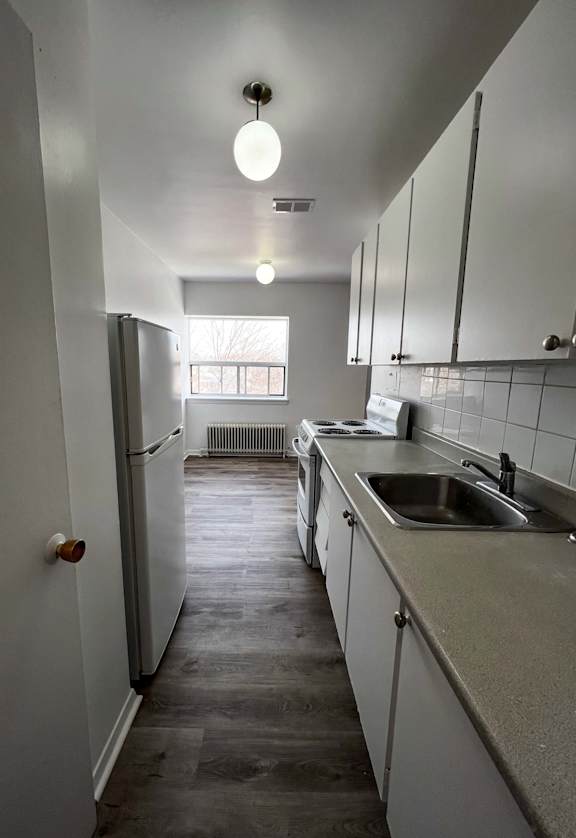 a small kitchen with a sink and a refrigerator
