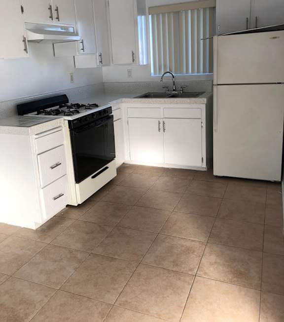 A well-lit, modern kitchen and living room with a dining area.