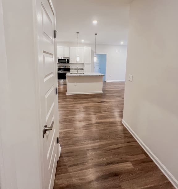 a kitchen and living room with white walls and wood floorsat Hamilton Reserve, Greensboro, NC
