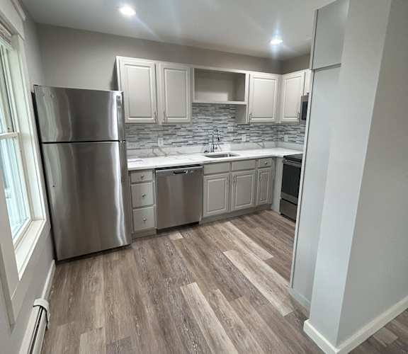a kitchen with white cabinets and stainless steel appliances at Briarcliff at Quechee Apartments, Vermont