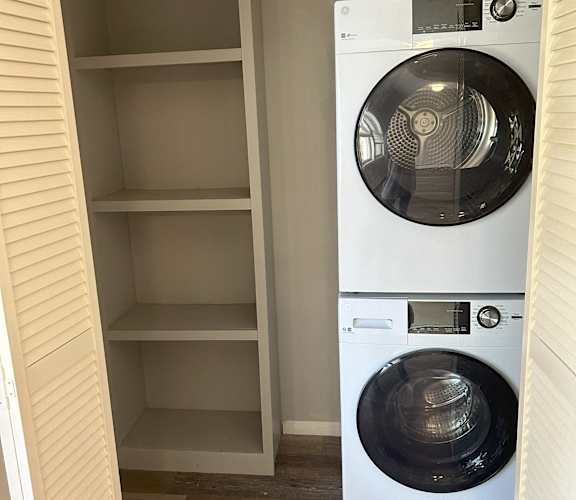 A white washing machine in a small laundry room. at Briarcliff at Quechee Apartments, Vermont