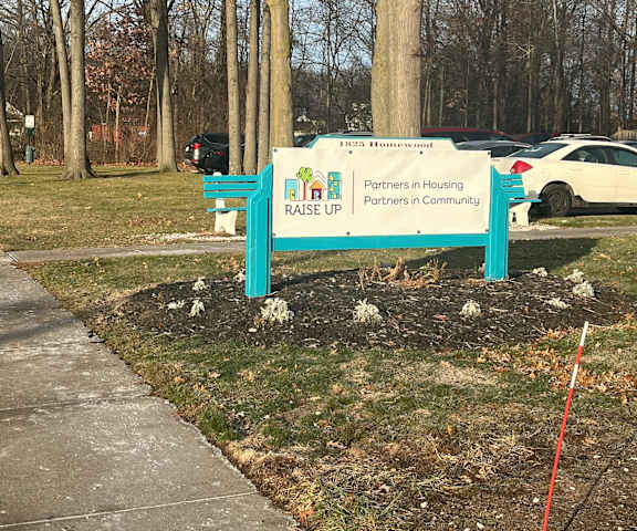 A sign for a house in a residential area.
