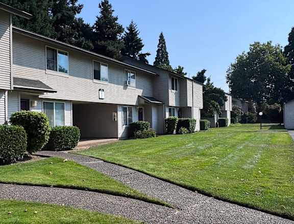 A tall building with a green lawn in front.