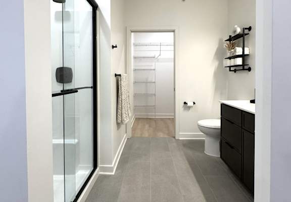 View of typical en-suite bathroom leading to walk-in closet from primary bedroom