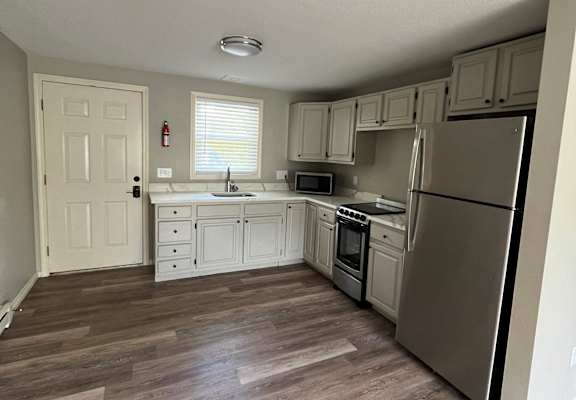 a kitchen with white cabinets and stainless steel appliances at Briarcliff at Quechee Apartments, Vermont