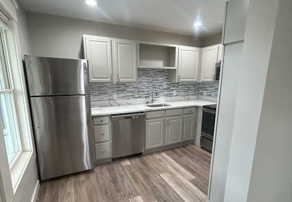 a kitchen with white cabinets and stainless steel appliances at Briarcliff at Quechee Apartments, Vermont
