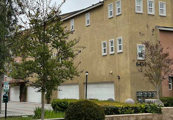 a building with two garages and a tree in front of it