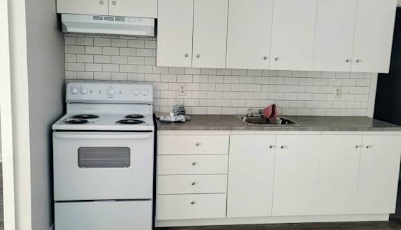 A kitchen with white cabinets and stainless steel appliances.
