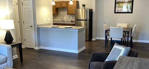 a view of a living room and a kitchen with a table and chairs
