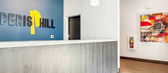 A reception area with a blue wall and a white reception desk.