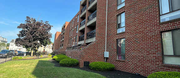 A red brick building with a green lawn in front.