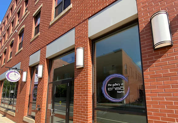 A building with a brick facade and a large window reflecting the sky.