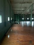 A long corridor with a metal railing and lights on the floor.