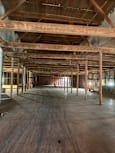 A long hallway with wooden beams and concrete walls.