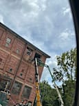A crane is lifting a large piece of equipment onto a building.