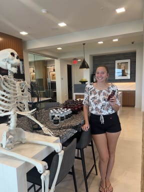 a woman standing next to a skeleton in a living room