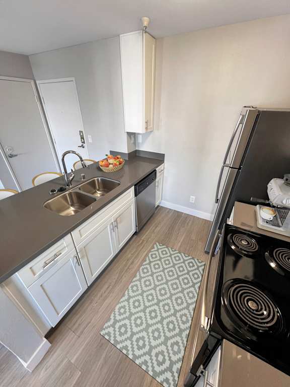 a kitchen with a sink and a stove and a refrigerator at Duet on Wilcox, Los Angeles