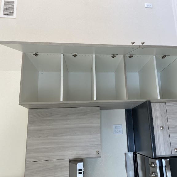 a kitchen with white cabinets and a refrigerator