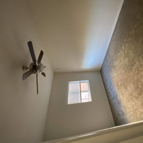 a view of a ceiling fan and a window in a room