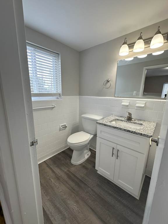 A white bathroom with a toilet, sink, and mirror.