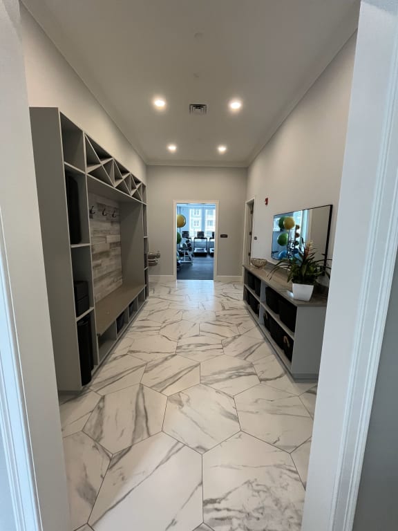 a look down the hallway of a house with a marble tiled floor at The Oasis at Plymouth, Massachusetts
