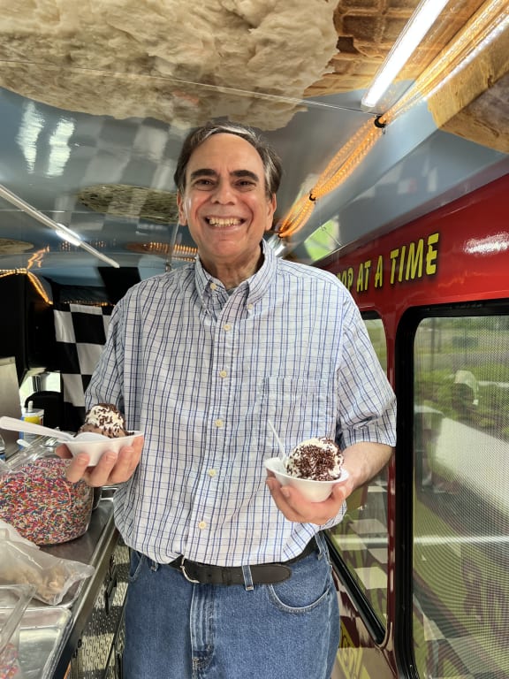 a man holding a doughnut at Station Bay, New Jersey, 08879