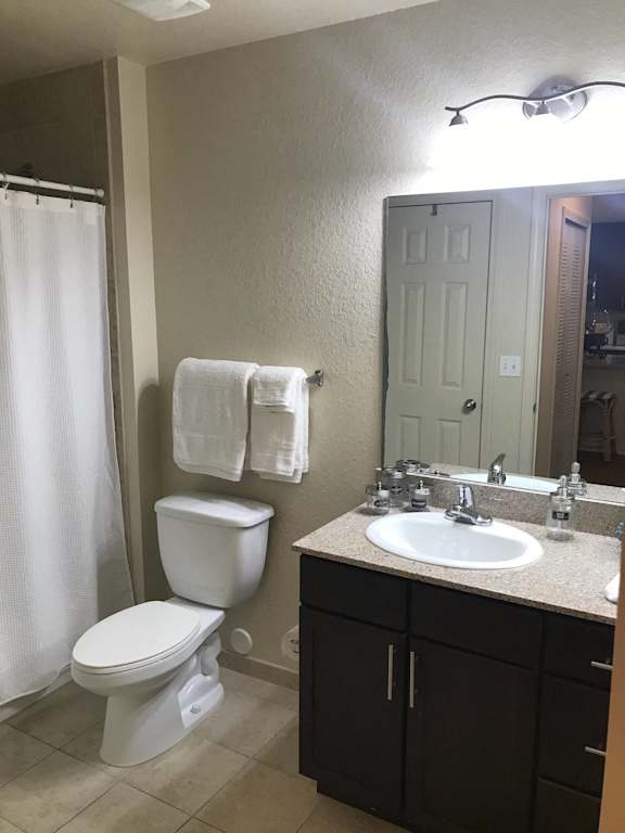 a bathroom with a toilet  at The Dakota Apartments, Florida 33458and a sink and a mirror