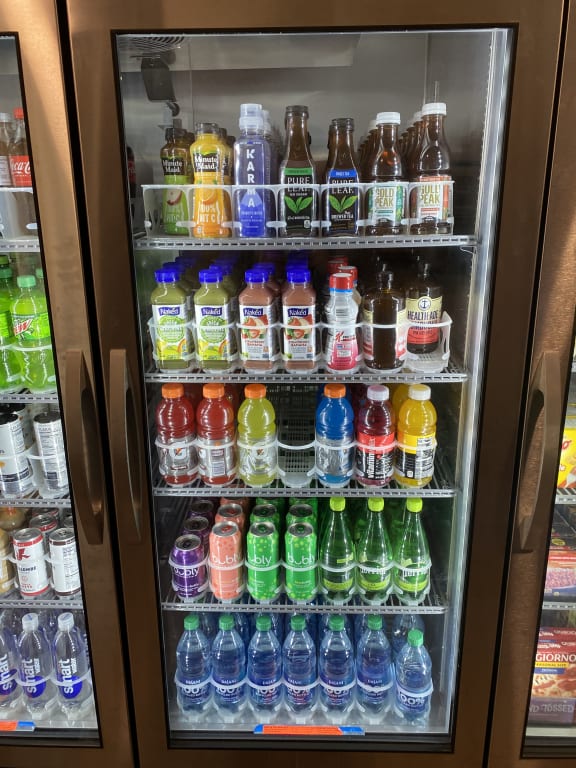 a refrigerated display case filled with colorful popsicles