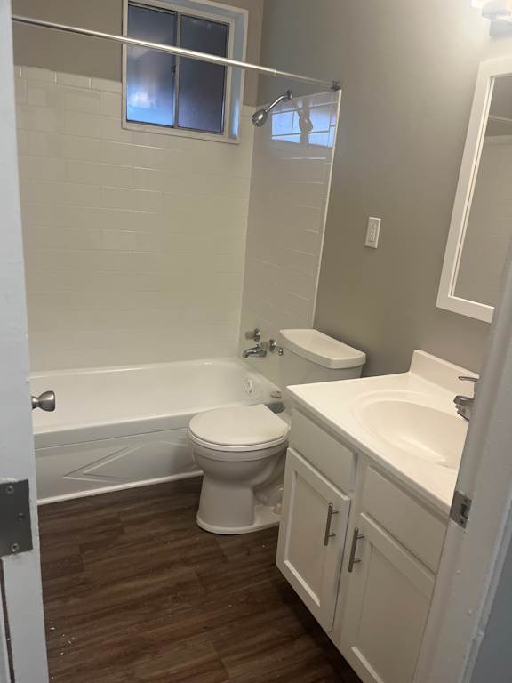 A white toilet sits next to a bathtub in a bathroom.