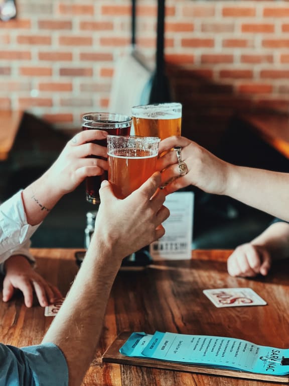 Group of Friends Toasting with Beers at a Bar