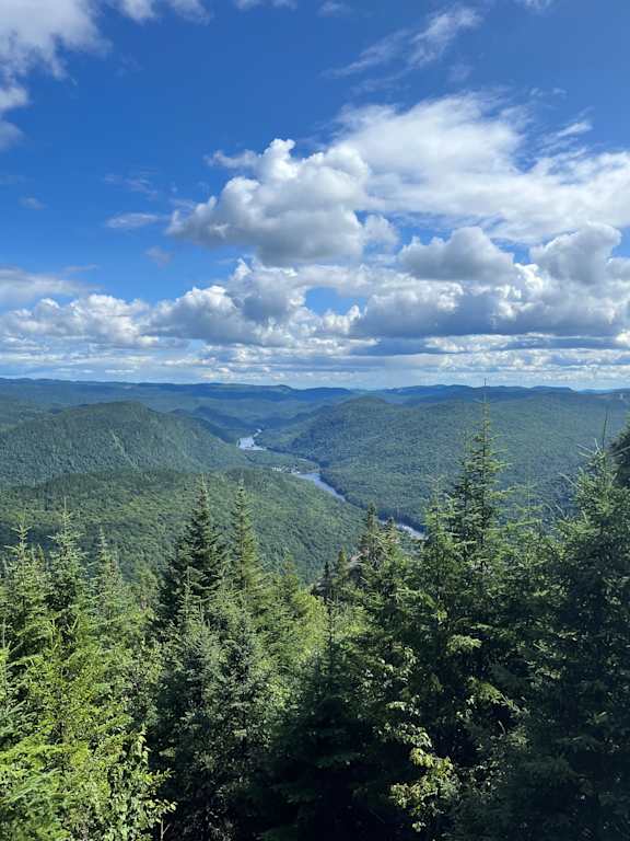 a view of the mountains and a river in the valley