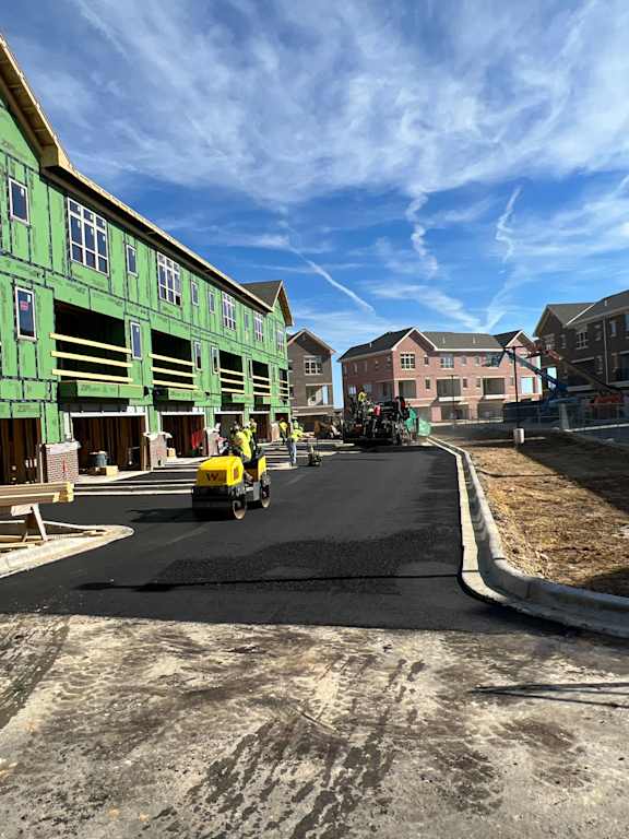 a construction site with a yellow truck driving down a street