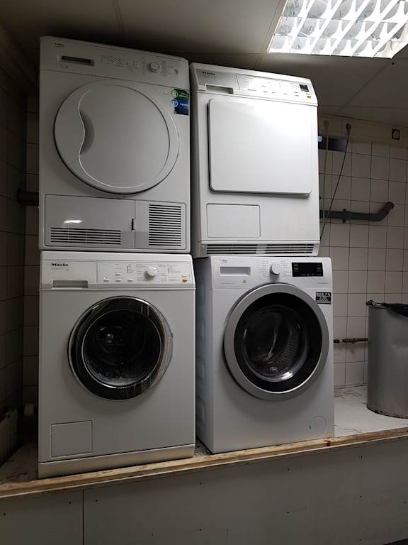 Two front loading washing machines stacked on top of each other.