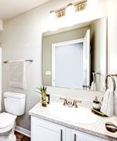 A bathroom with a white toilet, sink, and shower.