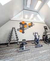 A gym with a variety of equipment including a rowing machine.
