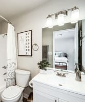 a bathroom with a white sink and toilet next to a bathtub with a shower curtain and