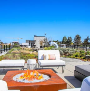 a patio with couches and a fire pit