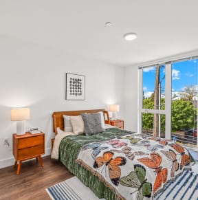 a bedroom with a bed and a large window