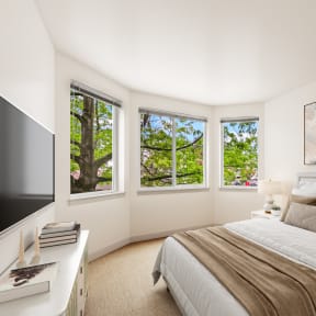 a bedroom with a bed and two windows