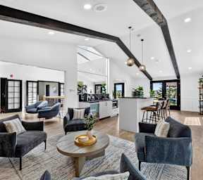  an empty living room with a fireplace and a kitchen